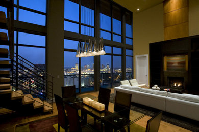 Example of a large trendy loft-style light wood floor and beige floor living room design in Nashville with yellow walls, a standard fireplace and a tile fireplace