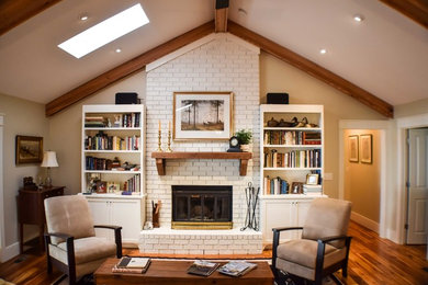 Inspiration for a timeless open concept medium tone wood floor living room remodel in Atlanta with beige walls, a standard fireplace and a brick fireplace