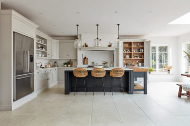 Photo of a modern l-shaped open plan kitchen in Manchester with shaker cabinets, beige cabinets, quartz worktops, white splashback, engineered quartz splashback, stainless steel appliances, porcelain flooring, an island, beige floors and white worktops.