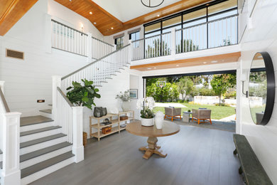 Expansive entryway in Orange County with white walls, medium hardwood floors and grey floor.