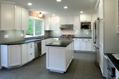 Example of a mid-sized transitional u-shaped ceramic tile and brown floor eat-in kitchen design in Portland with a double-bowl sink, white cabinets, soapstone countertops, gray backsplash, subway tile backsplash, stainless steel appliances, an island and shaker cabinets