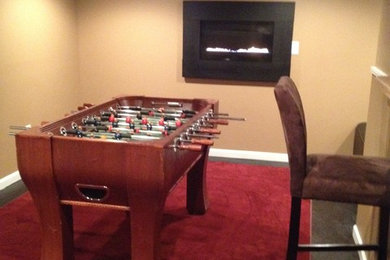 Example of a large trendy walk-out concrete floor basement design in Raleigh with a standard fireplace and beige walls