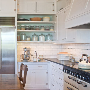 Diseño de cocina clásica con electrodomésticos blancos, armarios abiertos, puertas de armario blancas, salpicadero blanco y salpicadero de azulejos tipo metro