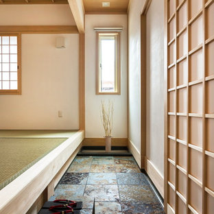 他の地域の引き戸和風のおしゃれな玄関ホール (白い壁、淡色木目調のドア、グレーの床) の写真