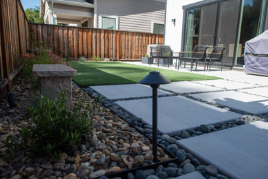 Design ideas for a small modern partial sun backyard concrete paver and wood fence lawn edging in San Francisco for spring.