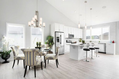 Inspiration for a huge transitional single-wall light wood floor eat-in kitchen remodel in Calgary with shaker cabinets, white cabinets, solid surface countertops, gray backsplash, matchstick tile backsplash, stainless steel appliances and an island