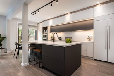 Inspiration for a mid-sized contemporary single-wall dark wood floor and gray floor eat-in kitchen remodel in Toronto with flat-panel cabinets, gray cabinets, quartzite countertops, white backsplash, an island and gray countertops