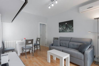 Foto de sala de estar actual con paredes grises, suelo laminado y suelo marrón