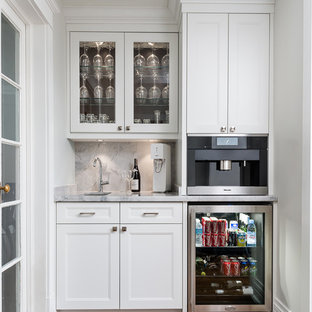 トロントの小さいコンテンポラリースタイルのおしゃれなウェットバー (アンダーカウンターシンク、落し込みパネル扉のキャビネット、白いキャビネット、大理石カウンター、グレーのキッチンパネル、石スラブのキッチンパネル、無垢フローリング) の写真
