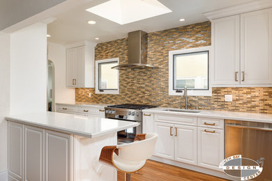 Example of a mid-sized transitional light wood floor and brown floor kitchen design in Los Angeles with an undermount sink, raised-panel cabinets, white cabinets, quartz countertops, brown backsplash, porcelain backsplash, stainless steel appliances and no island