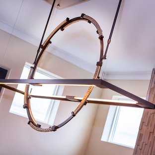 Exemple d'une grande salle à manger tendance avec un mur blanc, une cheminée standard et un manteau de cheminée en carrelage.