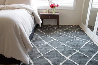 Photo of a mid-sized beach style bedroom in Sydney with beige walls and carpet.