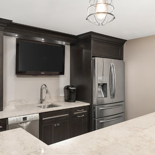 シカゴの大きいトランジショナルスタイルのおしゃれなウェットバー (アンダーカウンターシンク、シェーカースタイル扉のキャビネット、黒いキャビネット、クオーツストーンカウンター、クッションフロア、茶色い床、ベージュのキッチンカウンター) の写真