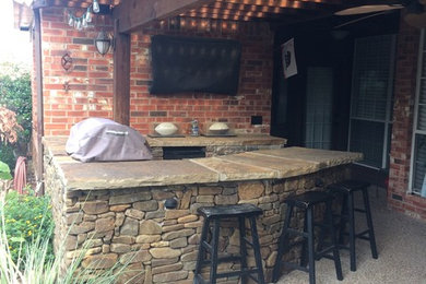Inspiration for a mid-sized backyard concrete patio kitchen remodel in Dallas with a pergola