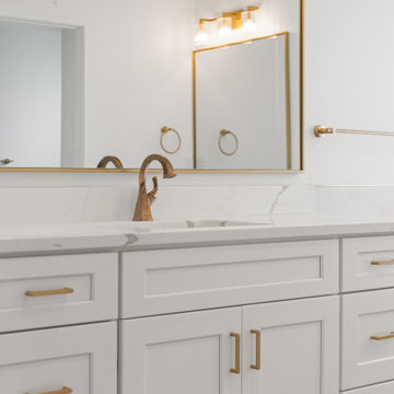Warm Transitional Two-Room Primary Bathroom