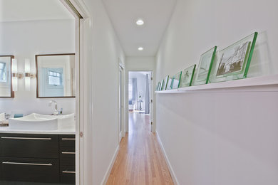 Inspiration for a large modern light wood floor hallway remodel in Columbus with white walls