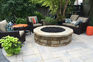 Design ideas for a mid-sized traditional backyard patio in Omaha with a fire feature and concrete pavers.