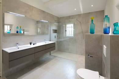 This is an example of a large transitional master bathroom in Other with a curbless shower, a wall-mount toilet, beige tile, cement tile, beige walls, limestone floors, beige floor and an open shower.