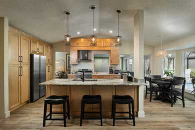 Mid-sized trendy kitchen photo in Tampa with shaker cabinets, medium tone wood cabinets, quartz countertops, stainless steel appliances, an island and beige countertops