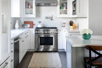 Inspiration for a mid-sized transitional u-shaped brown floor and dark wood floor kitchen remodel in San Diego with an undermount sink, white cabinets, quartz countertops, gray backsplash, ceramic backsplash, an island, white countertops, recessed-panel cabinets and stainless steel appliances