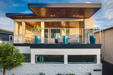 Inspiration for a midcentury two-storey stucco beige house exterior in Orange County.