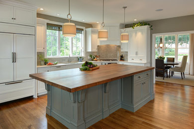 Large traditional eat-in kitchen in Boston with an undermount sink, beaded inset cabinets, white cabinets, wood benchtops, grey splashback, panelled appliances, medium hardwood floors, with island and brown floor.