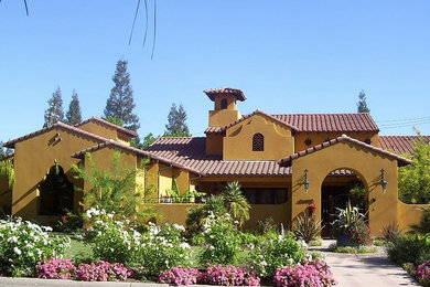 Example of a mid-sized tuscan brown one-story stucco gable roof design in San Luis Obispo
