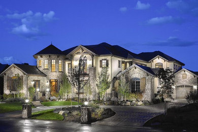 This is an example of a large mediterranean two-storey exterior in Denver with stone veneer.