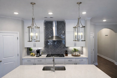 Eat-in kitchen - mid-sized u-shaped dark wood floor and brown floor eat-in kitchen idea in Atlanta with a single-bowl sink, shaker cabinets, white cabinets, quartzite countertops, gray backsplash, ceramic backsplash, stainless steel appliances, an island and white countertops