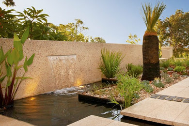 Small contemporary front yard full sun garden in Perth with a water feature and natural stone pavers for spring.