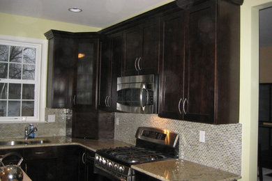 Mid-sized transitional u-shaped open concept kitchen photo in Philadelphia with a double-bowl sink, shaker cabinets, black cabinets, granite countertops, beige backsplash, mosaic tile backsplash, stainless steel appliances and an island