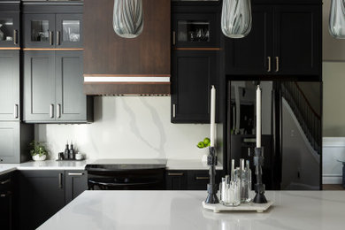 シアトルにある高級な中くらいなトランジショナルスタイルのおしゃれなキッチン (アンダーカウンターシンク、シェーカースタイル扉のキャビネット、黒いキャビネット、クオーツストーンカウンター、白いキッチンパネル、クオーツストーンのキッチンパネル、黒い調理設備、無垢フローリング、茶色い床、白いキッチンカウンター、三角天井) の写真