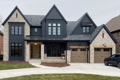 Transitional black two-story stone and board and batten exterior home photo in Chicago with a shingle roof and a gray roof