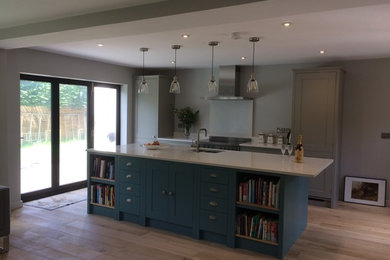 Mid-sized modern eat-in kitchen in Cheshire with shaker cabinets, quartzite benchtops, white splashback, stainless steel appliances, light hardwood floors and with island.