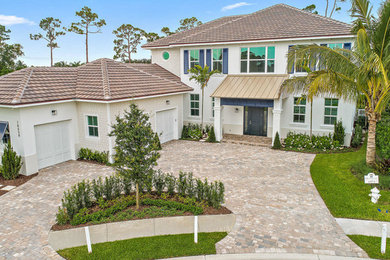 Large coastal white two-story stucco and shingle house exterior idea in Miami with a hip roof, a tile roof and a brown roof