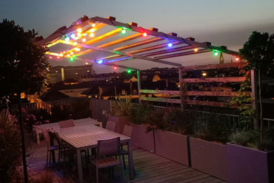 This is an example of a mid-sized beach style rooftop deck in Nantes with a container garden and a pergola.
