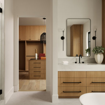 Clean, Ambient Master Bath Featuring Light Grays, White Surfaces, and Oak Detail