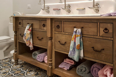 Example of a cottage bathroom design in Chicago with furniture-like cabinets, distressed cabinets and a trough sink
