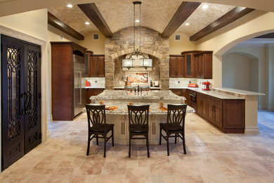 Inspiration for a large mediterranean l-shaped eat-in kitchen remodel in Orlando with shaker cabinets, dark wood cabinets, granite countertops, beige backsplash, stainless steel appliances and an island