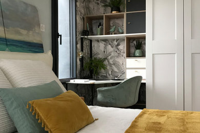 Cette image montre une chambre parentale minimaliste avec un mur vert, parquet clair, du papier peint et dressing.