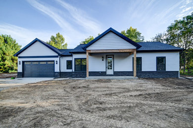 Large white one-story vinyl and clapboard exterior home idea in Other with a mixed material roof and a blue roof