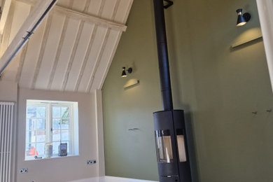 Photo of a large contemporary grey and cream open plan living room in Hertfordshire with beige walls, light hardwood flooring, a wood burning stove, a stone fireplace surround and exposed beams.