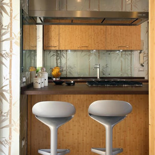 Esempio di una cucina ad U tropicale di medie dimensioni con ante lisce, ante in legno scuro, paraspruzzi multicolore, paraspruzzi con lastra di vetro, penisola e pavimento beige