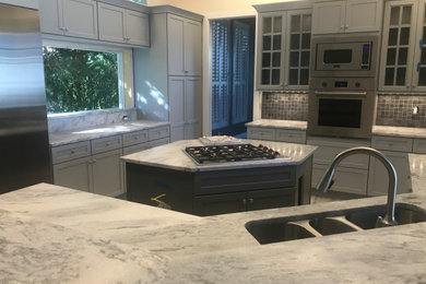 Inspiration for a large transitional porcelain tile and gray floor eat-in kitchen remodel in Miami with flat-panel cabinets, gray cabinets, marble countertops, gray backsplash, slate backsplash, stainless steel appliances, two islands and gray countertops
