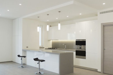 Idee per una cucina moderna di medie dimensioni con lavello integrato, ante bianche, top in quarzite, paraspruzzi grigio, elettrodomestici in acciaio inossidabile, pavimento in gres porcellanato, pavimento grigio e top grigio