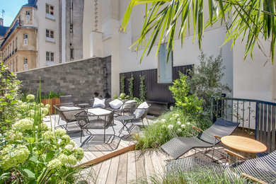 This is an example of a mid-sized modern rooftop and rooftop deck in Paris with an outdoor shower, no cover and wood railing.