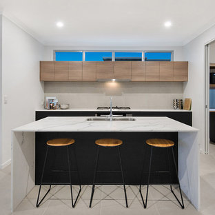 Large modern kitchen pantry appliance - Inspiration for a large modern galley porcelain floor and gray floor kitchen pantry remodel in Sunshine Coast with an undermount sink, light wood cabinets, marble countertops, gray backsplash, porcelain backsplash, stainless steel appliances, an island and white countertops