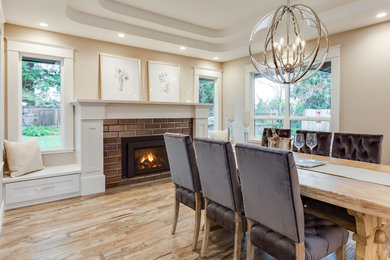 Inspiration for a large transitional medium tone wood floor and brown floor dining room remodel in Sacramento with beige walls, a standard fireplace and a tile fireplace