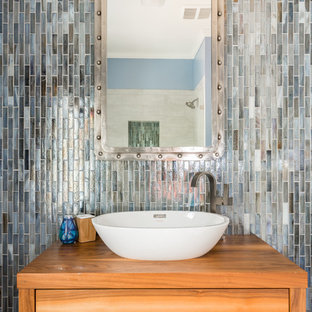 Inspiration for a small transitional green tile and ceramic tile dark wood floor and brown floor bathroom remodel in Atlanta with medium tone wood cabinets, a one-piece toilet, blue walls, a vessel sink and wood countertops
