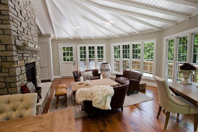 Living room - mid-sized traditional open concept dark wood floor living room idea in Minneapolis with gray walls, a two-sided fireplace, a stone fireplace and no tv